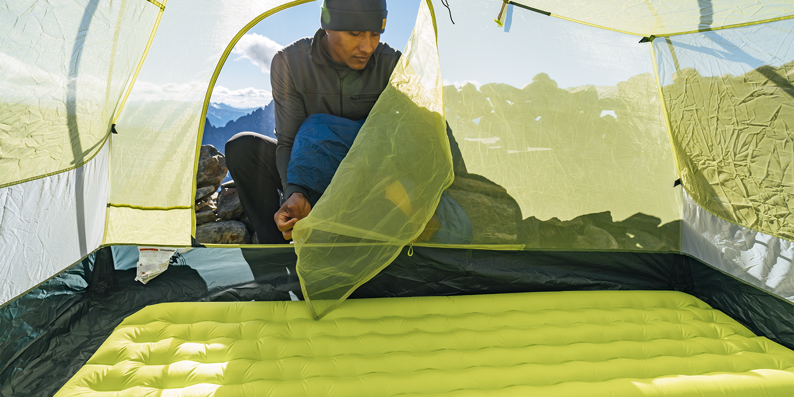 A hispanic hiker sets up his sleeping arrangements at the Sahale Glacier Camp in North Cascades National Park, Washington.